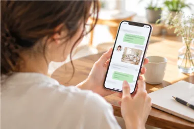 スマートフォンのメッセージで家事代行スタッフとやり取りする女性